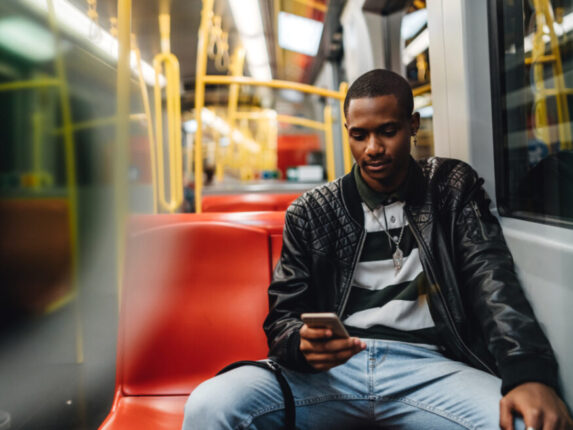 Foto von ein junger Mann mit Mobiltelefon in der Strassenbahn